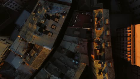 Rooftops-and-streets-of-Genoa-city-in-sunset-light,-drone-tilt-shot