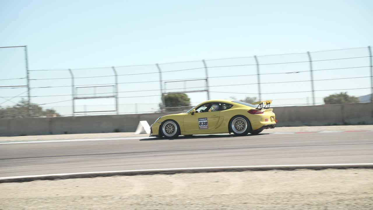 Slow motion panning shot of a sports car on a race track. Slow motion at 120 fps.