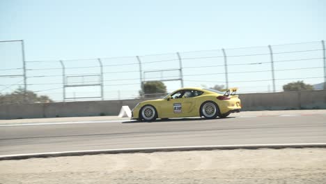 slow motion panning shot of a sports car on a race track. slow motion at 120 fps.