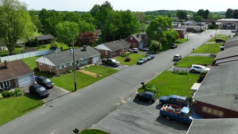 a drone flies parallel to a neighborhood street of a small town in america