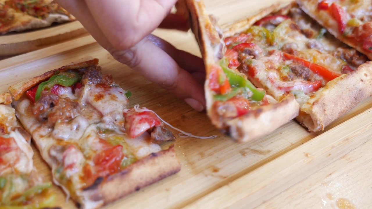 Mano che prende una deliziosa fetta di pizza con formaggio filante
