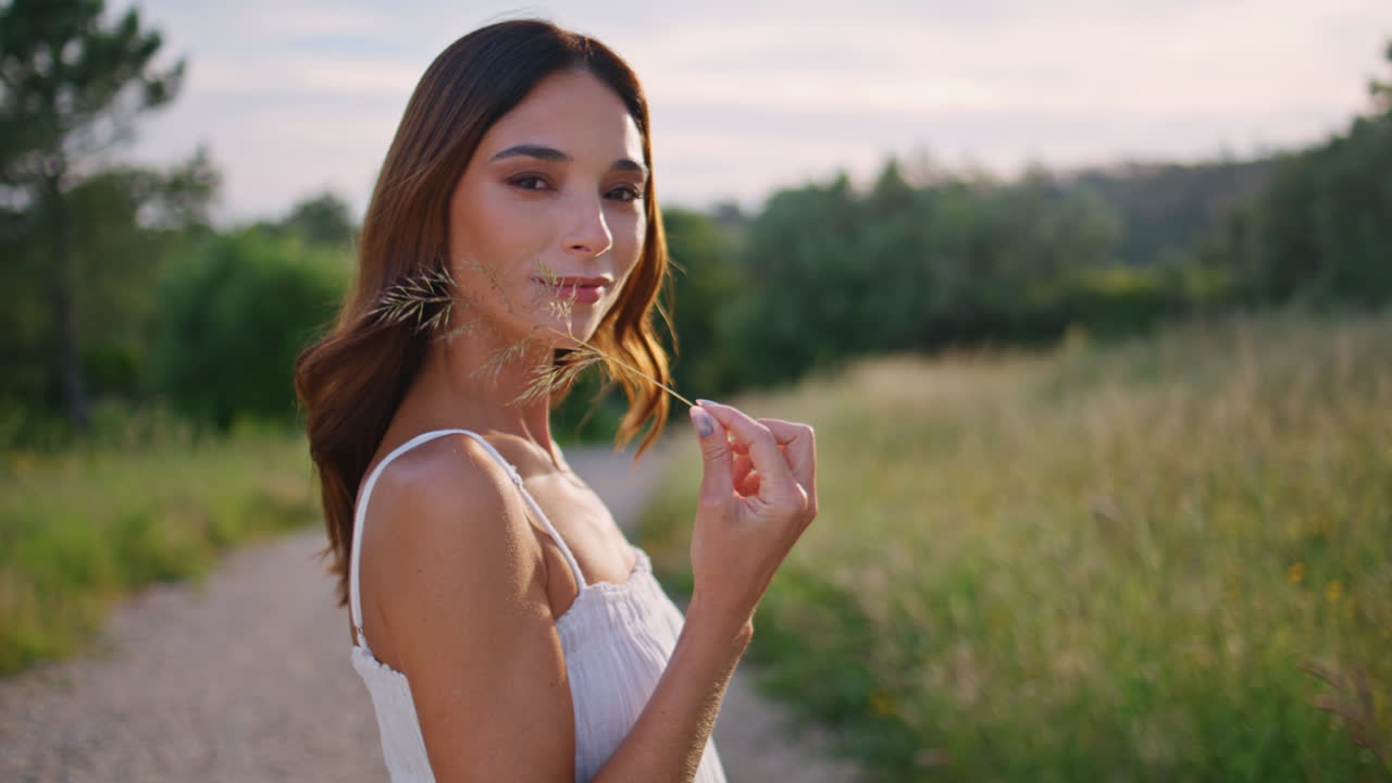 Portrait countryside woman holding spikelet in rural nature. Lady looking camera