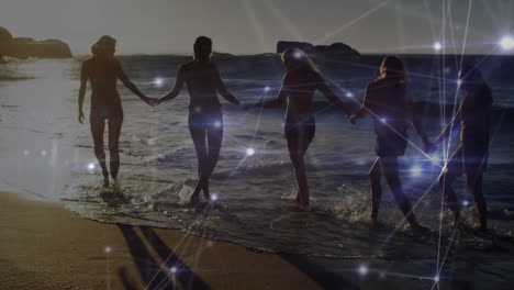 animation of networks of connections over happy group of friends having fun, walking along beach