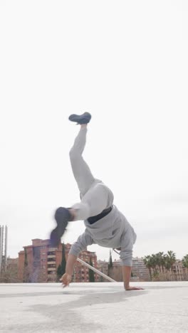 breakdancer performing handstand and flip on rooftop
