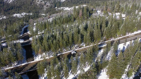 un avión no tripulado se inclina sobre la nevada autopista interestatal 80 en las tierras altas de la invernal california, estados unidos.
