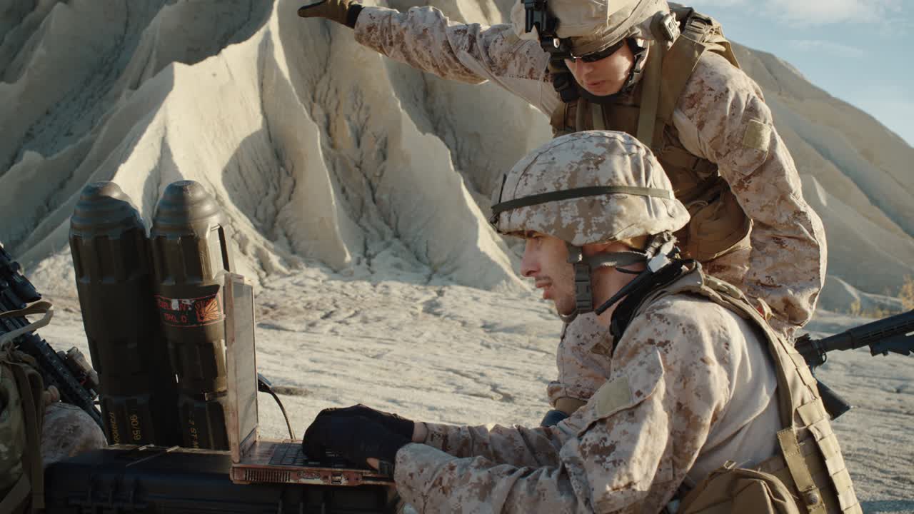 Soldiers are Using Laptop Computer for Surveillance During Military Operation in the Desert. Slow Motion.