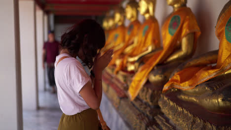 asian woman praying with buddha in temple