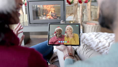 dos parejas felices con tabletas de navidad llamada de video, cámara lenta