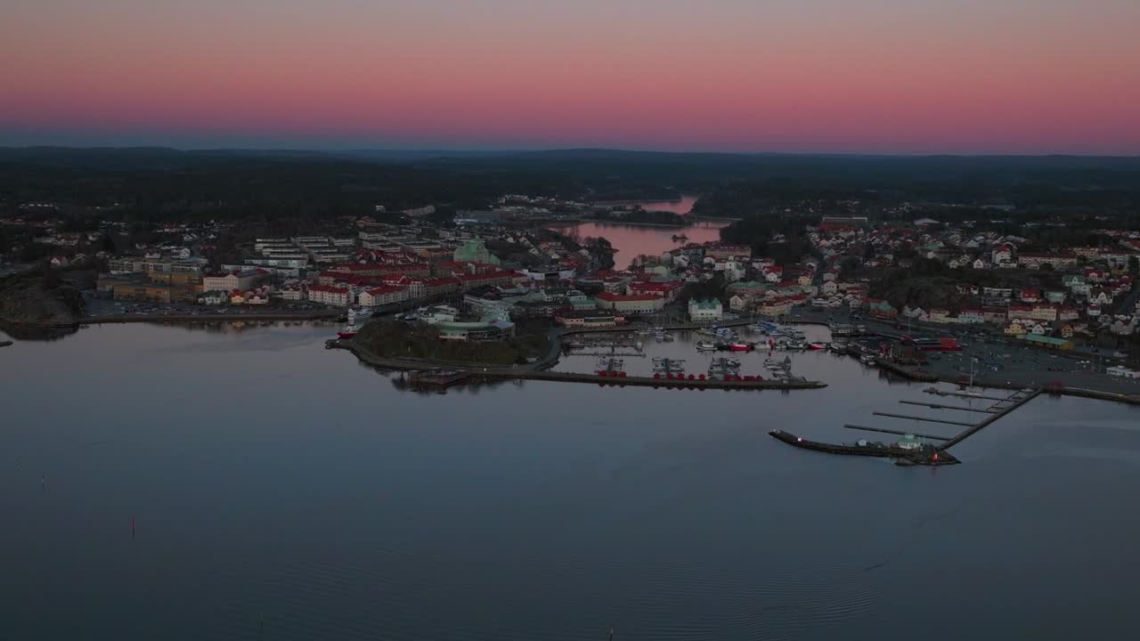 Calm orange pink sunset Strömstad Stromstadr Sweden aerial drone Sandelfjord Fjord seaside town boats in marina harbor Scandinavia Arctic Circle Skagerrak Baltic Sea Sverige forward pan up motion