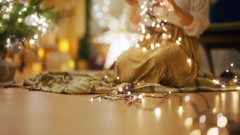 woman with christmas lights in cozy, family interior