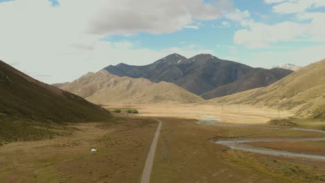 Vista-Aérea-De-Un-Valle-Seco-De-Nueva-Zelanda-Con-Un-Río-Estrecho-Y-Sinuoso