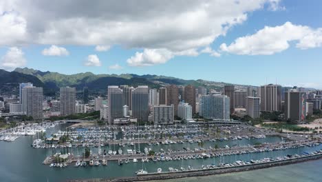 aerial reverse pullback shot of a yacht marina in downtown honolulu, hawaii