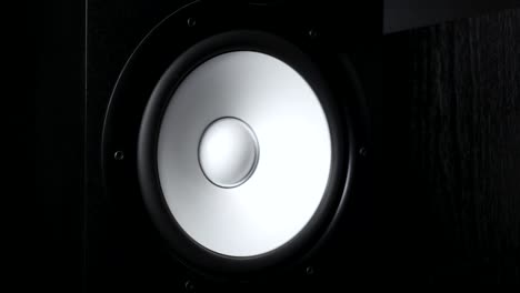 close up of moving sub-woofer on recording studio. white speaker pulsating and vibrating from listening of loud music on low frequency. work of modern high fidelity loudspeaker membrane. slow motion