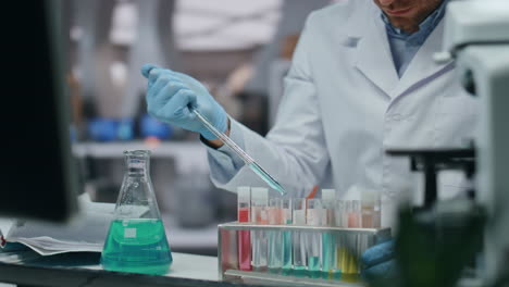 microbiólogo de mano con pipeta trabajando en el laboratorio de la clínica de farmacología de cerca.
