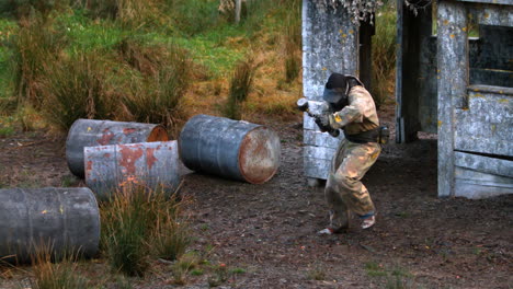 hombre saliendo del refugio y siendo disparado en paintball