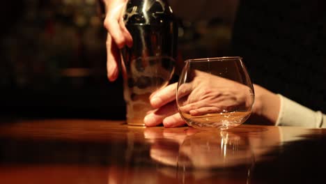 bartender pours and mixes drinks at a bar