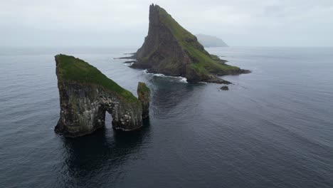 Drangarnir-sea-stacks,-Tindholmur-and-Mykines-covered-by-fog-in-background