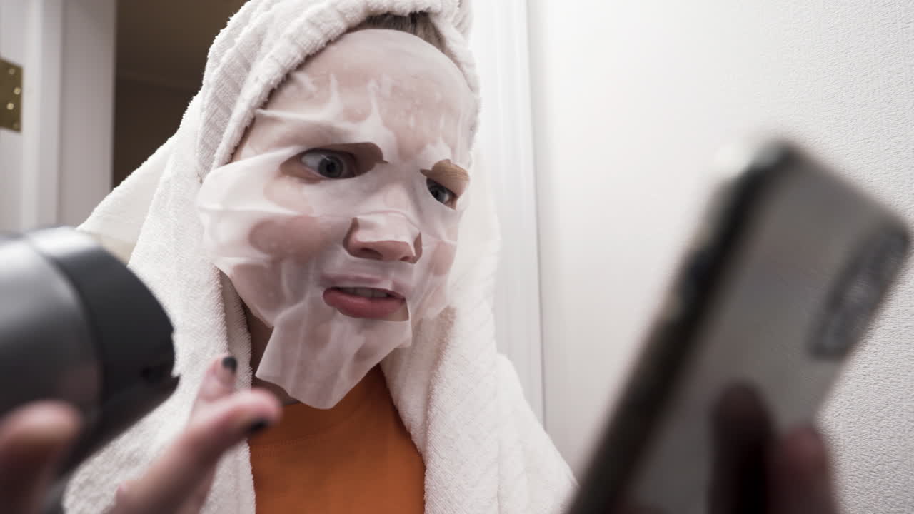 Woman with face mask having a video call in the bathroom