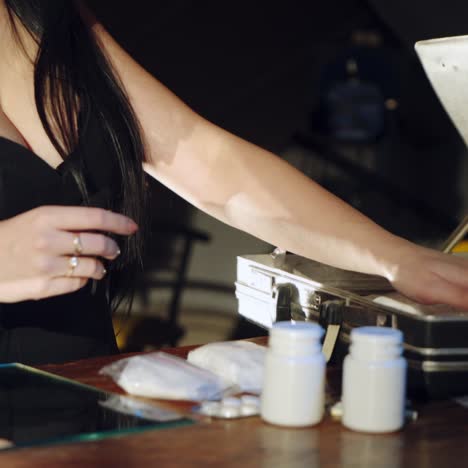 a man and a woman are packing drugs in a suitcase for sale. drug trade. illegal business