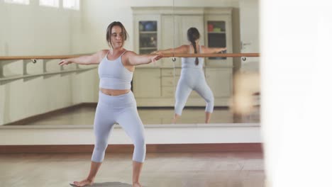 Mujer-Caucásica-Enfocada-Practicando-Yoga-En-El-Gimnasio,-Cámara-Lenta