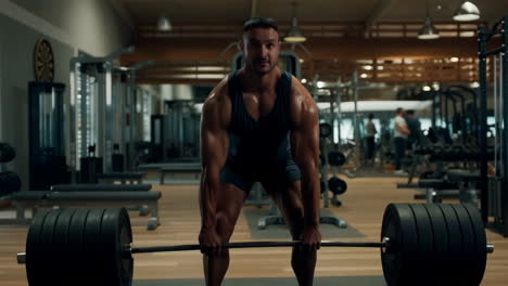 muscular man performing a deadlift in a gym