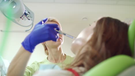 dentist doing anesthetic injection in sick tooth. female stomatologist