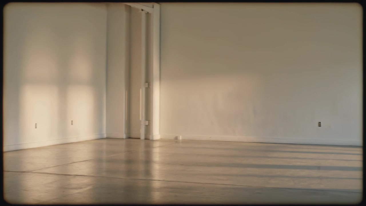 Telecamera panoramica che si muove attraverso un loft vuoto, mostrando colonne, fasce di luce, presa di corrente per mostrare l'interno