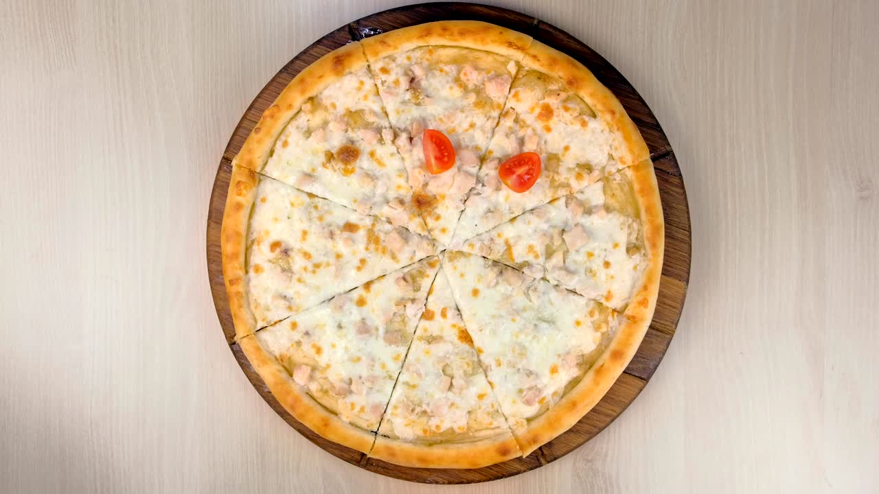 요리사는 피자에 토마토와 을 넣고 고기와 치즈를 나무판에 넣습니다.