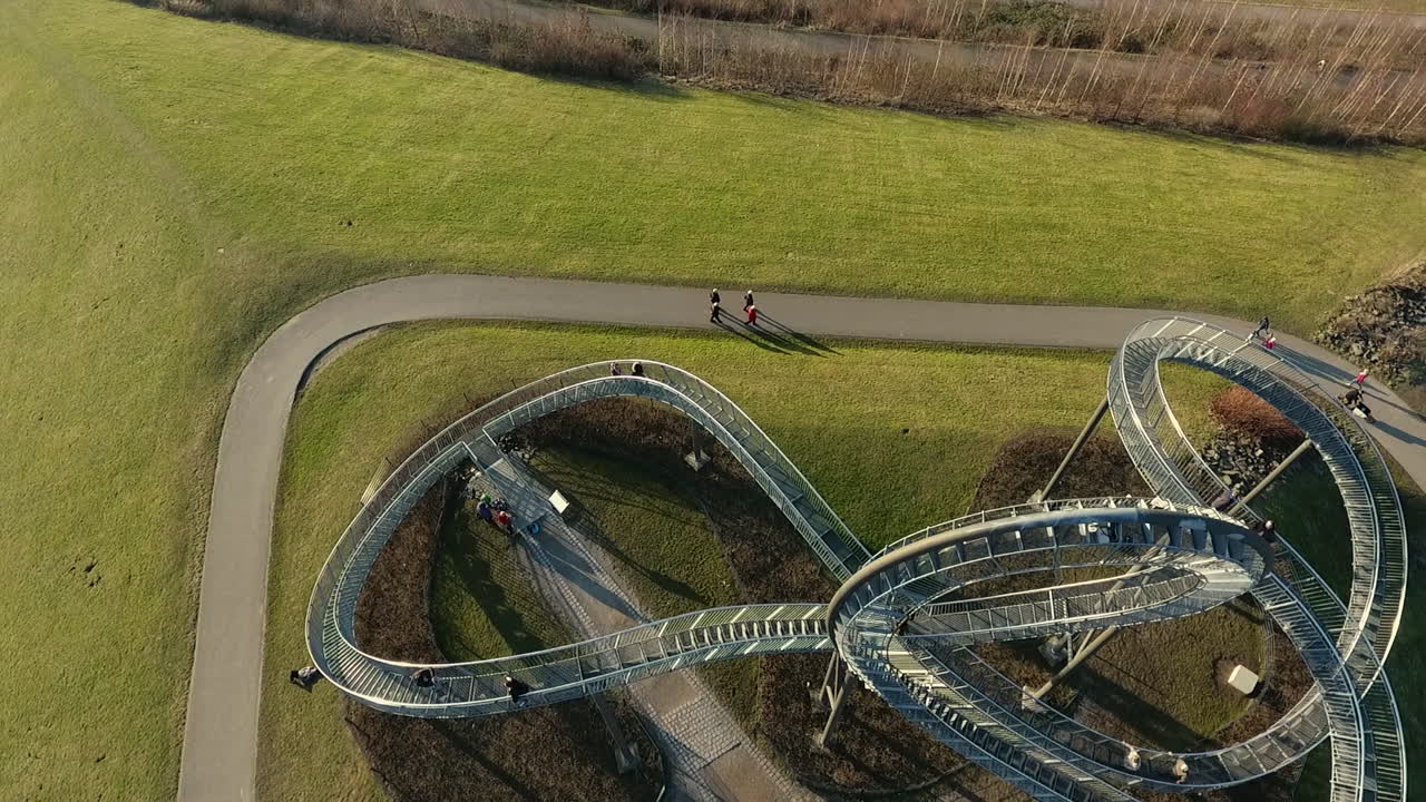 Drone clip of the walking rollercoaster Magic mountain in Duisburg. In this clip the picture is following a bike.