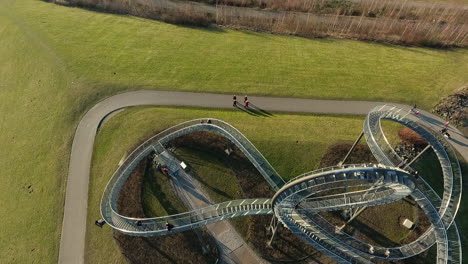 drone clip of the walking rollercoaster magic mountain in duisburg. in this clip the picture is following a bike.