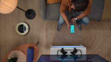 man using smartphone in living room with smart home devices