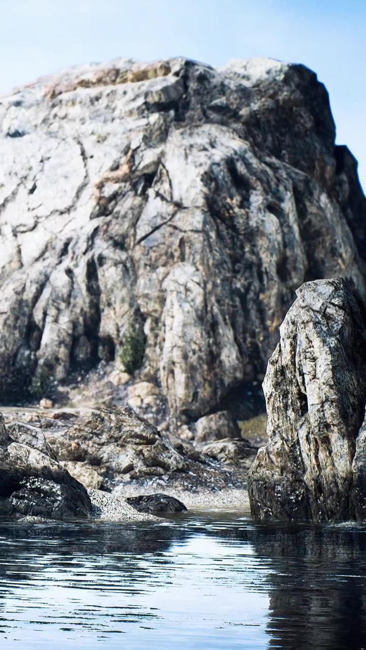 Rocce di granito si riflettono nell'acqua su una riva remota durante le ore diurne.