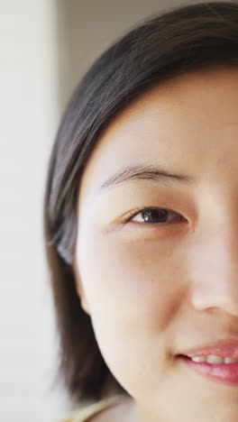Vertical video of portrait of happy asian woman in living room