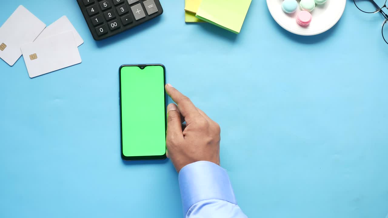 top view of man hand using smart phone on office desk