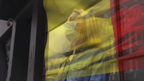 Animation-of-flag-of-belgium-waving-over-caucasian-woman-wearing-face-mask-in-city-street