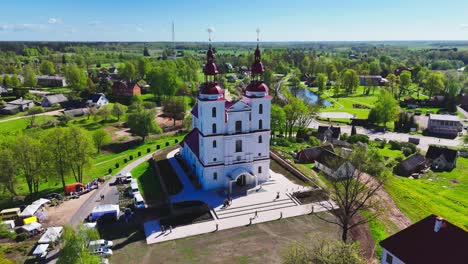 beautiful aerial view of a church in lithuania, with green fields and small town buildings