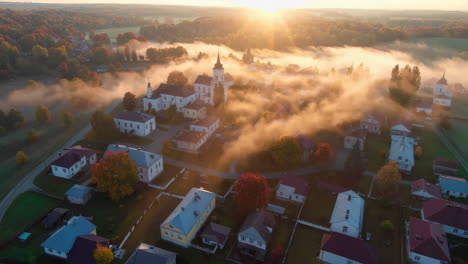 aerial view of a european village covered in morning mist during sunrise