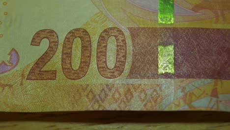 this is the macro view of a normal paper banknote- money- currency of 200 south african rand