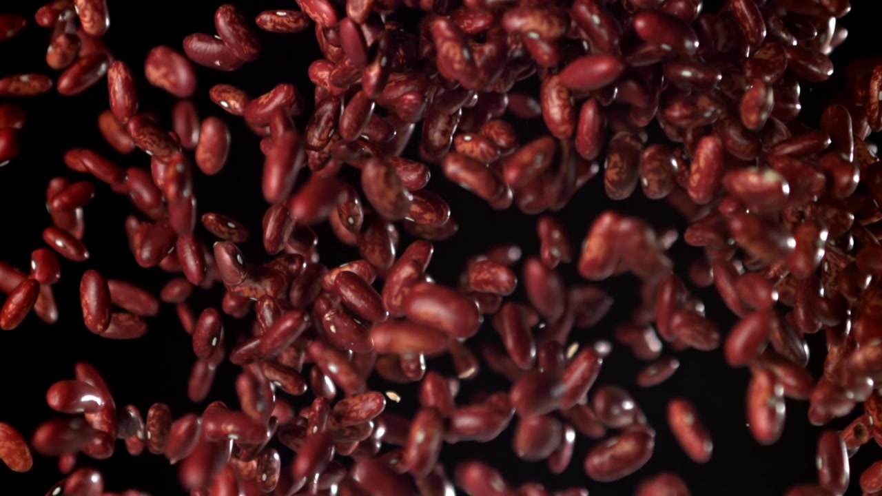 Red Kidney Beans Falling in Slow Motion Against a Black Background