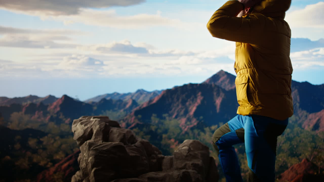 joven buscador de aventuras tomando fotos en la cima de la montaña usando su teléfono