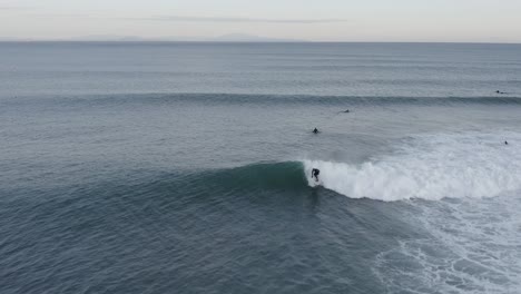 surfista golpeando el hombro de la ola en el agua fría del océano atlántico, antena