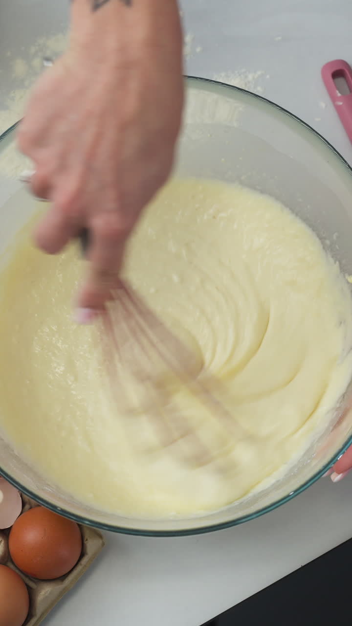 Vertical View Of A Hand Whisking Pancake Batter. Overhead Shot