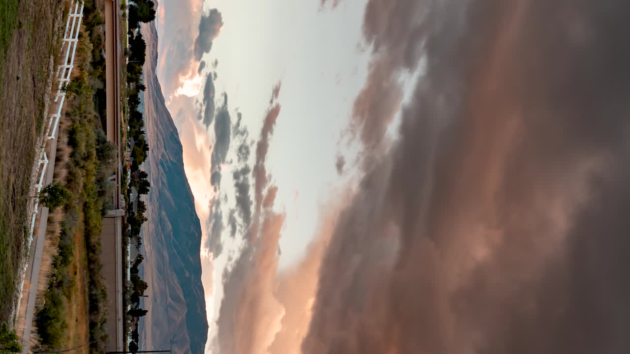 lapso panorámico de nubes tormentosas al atardecer sobre un paisaje montañoso - orientación vertical