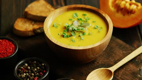 Fresh-pumpkin-soup-in-bowl-on-chopping-board