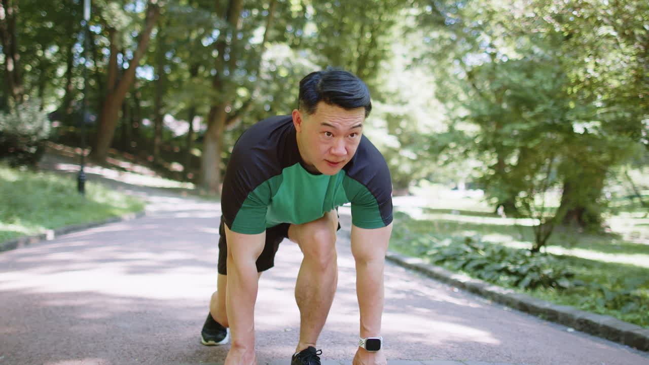 Asian athletic sport motivated runner man training preparing to run race marathon in morning park