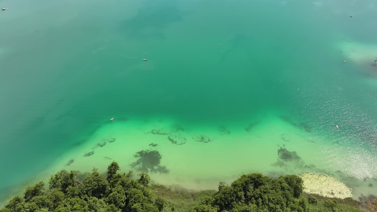 A bird's eye view of the clear Hallwilersee lake. A shot of a nearby shipyard with small boats for rent to visitors