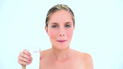 Smiling-woman-drinking-a-glass-of-milk