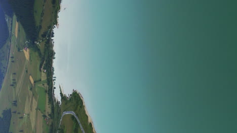 clip aéreo de formato vertical sobre un gran embalse detrás de la presa de frumoasa, rumania