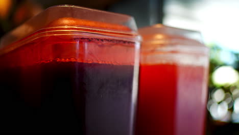 cranberry and grapefruit juice dispensers standing side by side, showcasing vibrant colors and refreshing beverage options in commercial setting