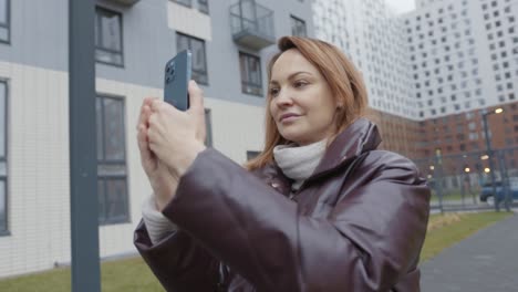 mujer tomando una foto con un teléfono inteligente en la ciudad